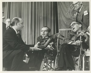 A man presents the 1970 President's Trophy to Richard and Robert Santin