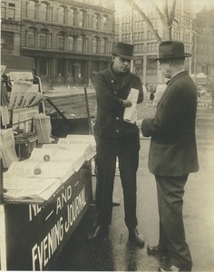 A man missing both of his arms sells newspapers