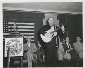 Unidentified man playing an acoustic guitar at an ICD event