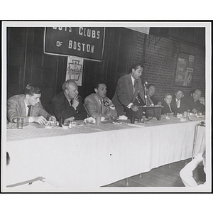 A man speaking at the head table during an awards event held by the Boys' Clubs of Boston and the Knights of Columbus Bunker Hill Council