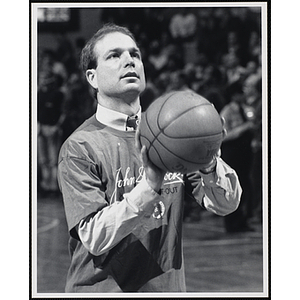 Former NBA player Jerry Sichting holding a basketball and looking up at a fund-raising event held by the Boys and Girls Clubs of Boston and Boston Celtics