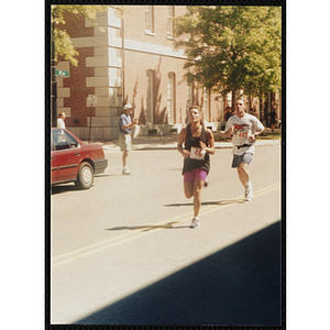 A woman and run by a spectator during the Battle of Bunker Hill Road Race