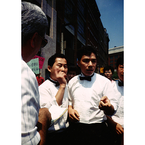 Three male Dynasty Restaurant employees talk to a reporter and demonstrators