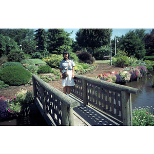 Young woman stands on a footbridge in a Vancouver botanical garden
