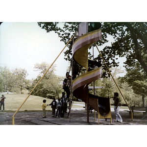 Children climb the stairs to a spiral slide