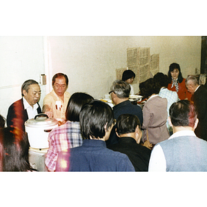 People wait to get their food at a buffet table during a Thanksgiving celebration