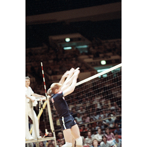 Men's United States Volleyball Team member jumps to block a ball during a game against the Chinese Team