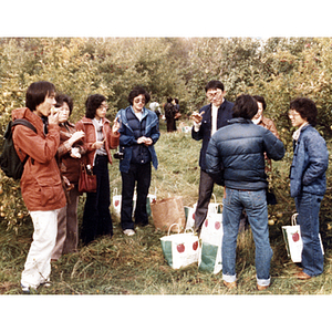 People eating apples during a Chinese Progressive Association trip