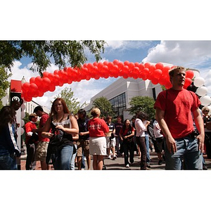 Students pass under an arch of balloons at the President's barbecue