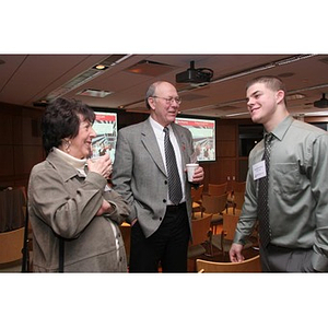 Joseph Bordieri converses with a man and woman at a Torch Scholars event