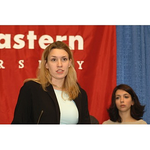 Student speaking at podium during press conference on student aid