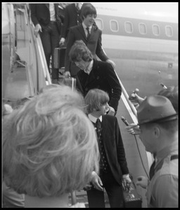Ringo Starr, George Harrison, and Paul McCartney descending the ramp from a Pan American airways Boeing 707