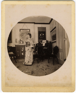 Abby F. Blanchard in the parlor, with parasol and kimono