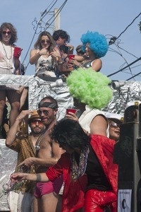 Parade marchers throwing strings of beads from a float : Provincetown Carnival parade
