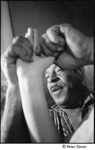 Karmu (Edgar Warner) massaging a patient's hand