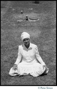 Woman in a turban seated in a lotus position on the lawn during Ram Dass's appearance at Sonoma State University