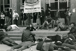Staged die-in at UMass Amherst, beneath banner reading 'Preparation for nuclear war is preparation for suicide'
