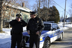 Two New Salem town police officers standing by their patrol car in front of the Stowell Building