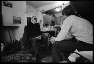 W. Eugene Smith, seated at a desk, talking with unidentified man