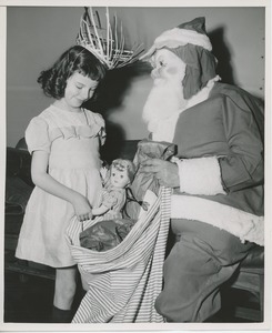 Santa Claus with young girl and bag of gifts