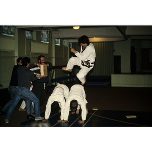 Man jumping towards a block in a martial arts class