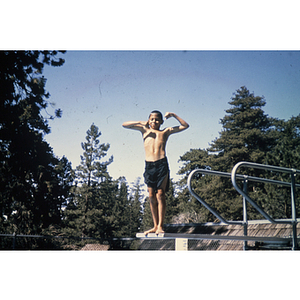 Child posing on diving board outdoors