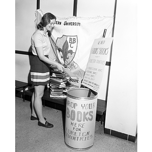 Janet Shoemaker drops a book into a donation bin