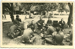 Soldiers sitting on the ground having a meal