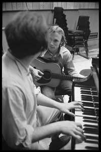 Stephen Stills with his guitar talking with Michael Sahl on piano at Wally Heider Studio 3 during production of the first Crosby, Stills, and Nash album