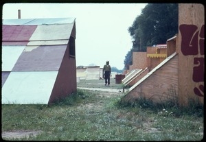 Man walking among plywood tents at the Resurrection City encampment