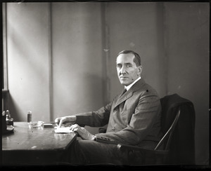 Frank W. Buxton, seated at his desk
