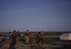 Eskimo men and boys run a three-legged race.