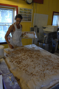 Hungry Ghost Bread: owner and baker Jonathan C. Stevens spreading filling dough for cinnamon rolls