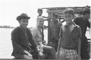 Bruce Kinsey with civilians on a river boat; Can Giuoc District.