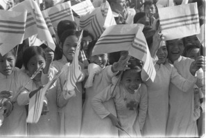 Children of refugees from North Vietnam waving a national Vietnamese flag to welcome General Khanh.