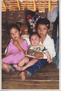 A photograph of three children at a birthday celebration in Thailand, 2010