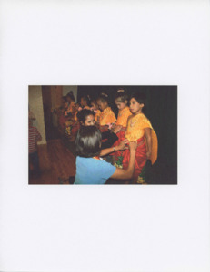 Photograph of women fixing the clothing of young Angkor Dance Troupe members, 2005