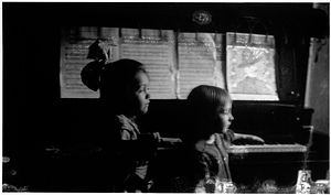 Two girls at a piano in the Back Central Street neighborhood. [01]