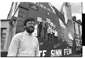 Gerry Adams, President of Sinn Fein, posing in front of a Sinn Fein republican wall mural on the Falls Road, Belfast