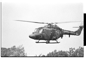 Ballygawley, Co. Tyrone bus bomb in which eight British soldiers were killed. Shot of helicopter flying over the scene with the crew watching the photographer