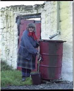 Old woman at water barrel in co. Tyrone