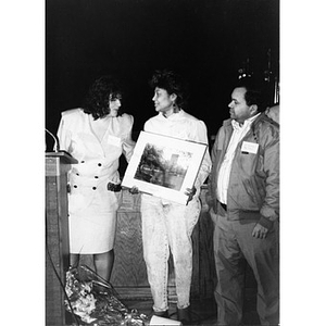 Inquilinos Boricuas en Acción board members presenting a woman with a framed photograph.