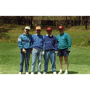 A four-man golf team posing on the golf course at a Boys & Girls Club Golf Tournament