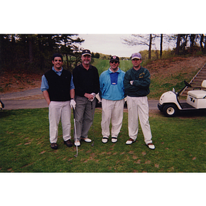 A four-man golf team standing in front of a golf cart at the Charlestown Boys & Girls Club Annual Golf Tournament