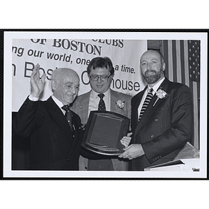 Ed Hoell, at right, and an unidentified man present a plaque at a St. Patrick's Day Luncheon