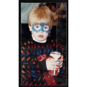 A boy with his face painted holding a beverage can and looking at the camera at a joint Charlestown Boys and Girls Club and Charlestown Against Drugs (CHAD) event