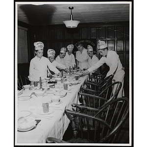 Members of the Tom Pappas Chefs' Club set a table as Chef's Club Committee member Mary A. Sciacca looks on