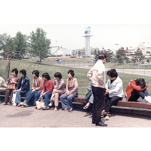 Chinese Progressive Association members sit outside an amusement park