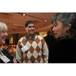 Danny Vazquez stands with two women at a Torch Scholars event