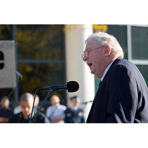 Neal Finnegan speaks into a microphone at the Veterans Memorial dedication